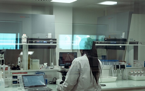 Scientifique travaillant avec des équipements de laboratoire, vue à travers une vitre