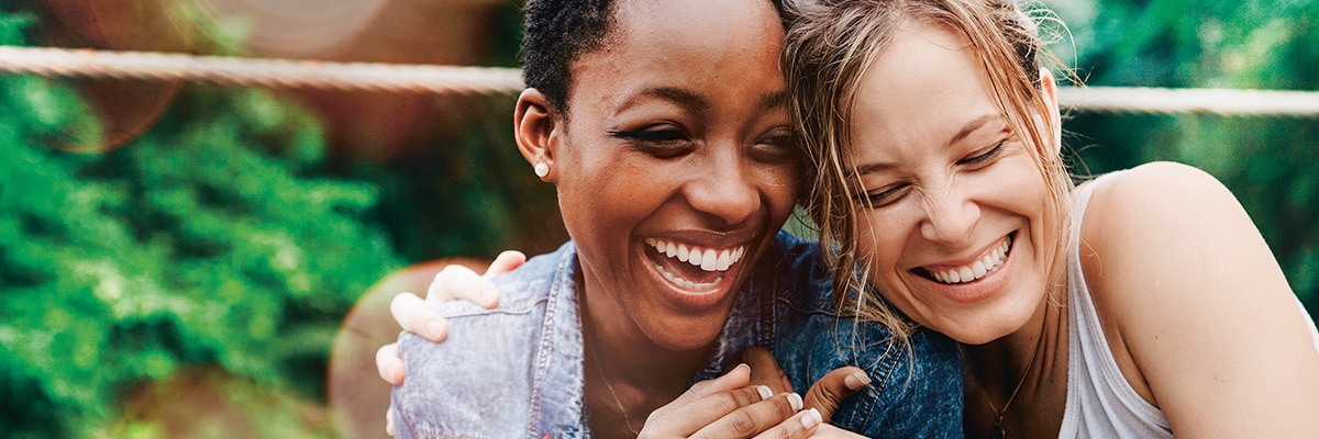 Deux femmes en extérieur rient ensemble