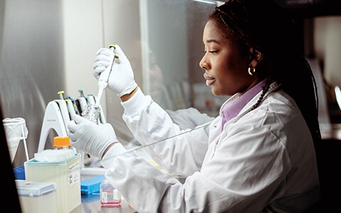 1 femme noire scientifique effectuant une analyse en laboratoire