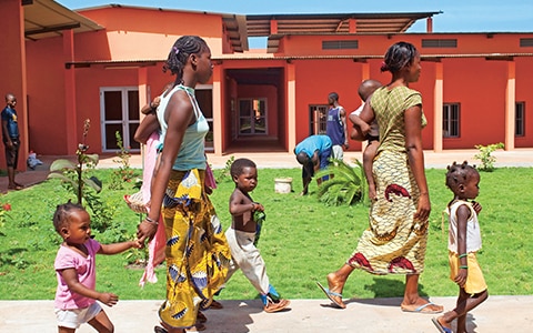 Centre de recherche sur la drépanocytose à Bamako, Mali. Une femme qui marche en tenant des enfants
